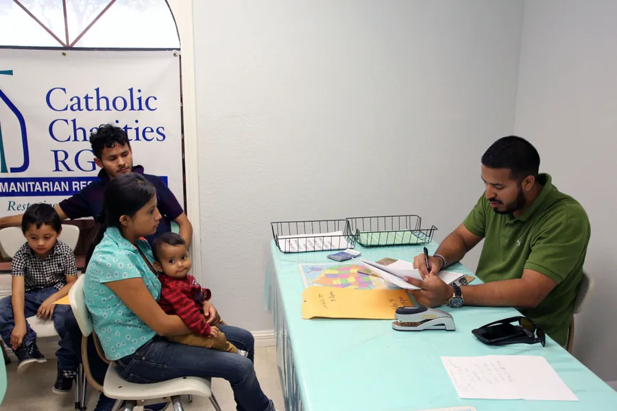 Aug. 17, 2017 - A volunteer at the Catholic Charities Humanitarian Respite Center in McAllen, Texas helps a Central American refugee family?w=200&h=150